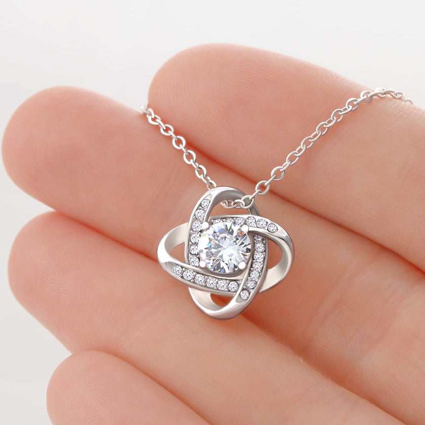 Silver love knot necklace with a sparkling center stone  symbolizing eternal love and romantic connection.