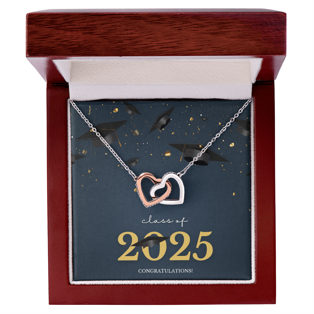 A gold interlocking hearts necklace displayed in a cherry wood box with a message card that reads "Class of 2025 – Congratulations" featuring graduation caps and celebratory confetti.