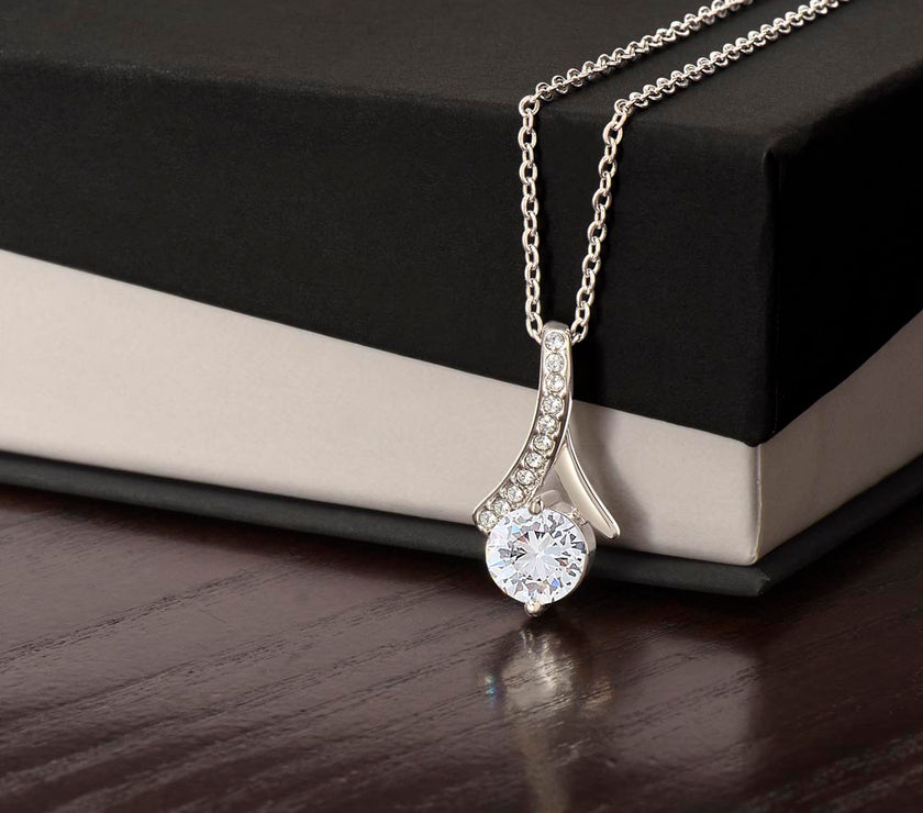 Alluring Beauty necklace features a petite ribbon shaped pendant.. white gold finish