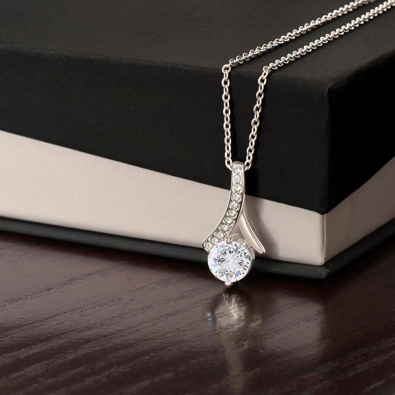 Alluring Beauty necklace features a petite ribbon shaped pendant.. white gold finish