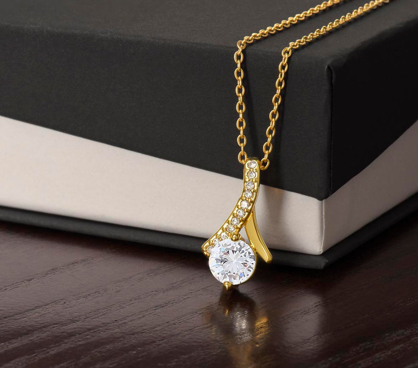 Alluring Beauty necklace features a petite ribbon shaped pendant.. 18k yellow gold finish