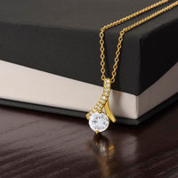 Alluring Beauty necklace features a petite ribbon shaped pendant.. 18k yellow gold finish