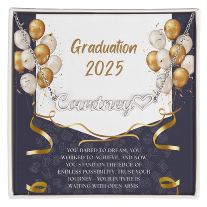 Close-up of hands holding an open red gift box featuring a personalized gold name necklace with heart, set against a message card that reads "Graduation 2025" and includes an inspiring graduation quote, with gold and white balloons in the background.