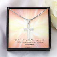 Silver cross necklace displayed in a red gift box with a radiant background and an inspirational message that reads: 'Let this cross be a symbol of the journey — a path walked in grace, guided by love, and grounded in unwavering faith