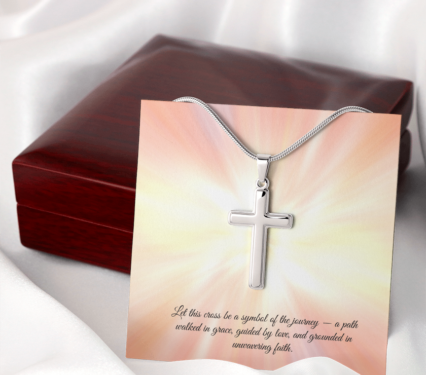 Silver cross necklace displayed in a red gift box with a radiant background and an inspirational message that reads: 'Let this cross be a symbol of the journey — a path walked in grace, guided by love, and grounded in unwavering faith