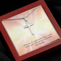 Silver cross necklace displayed in a red gift box with a radiant background and an inspirational message that reads: 'Let this cross be a symbol of the journey — a path walked in grace, guided by love, and grounded in unwavering faith