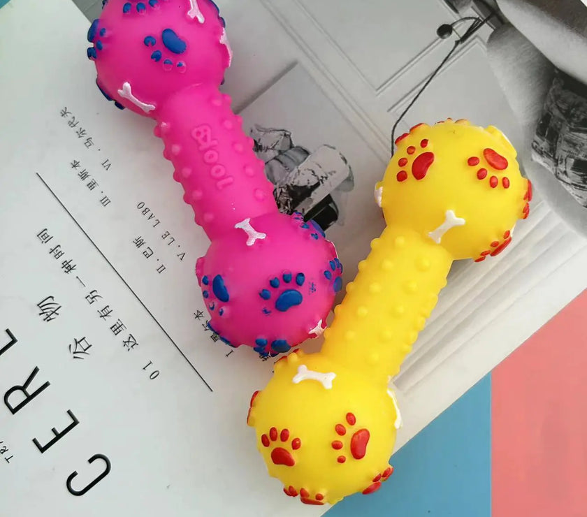 Two colorful dog toys shaped like dumbbells on a magazine page.