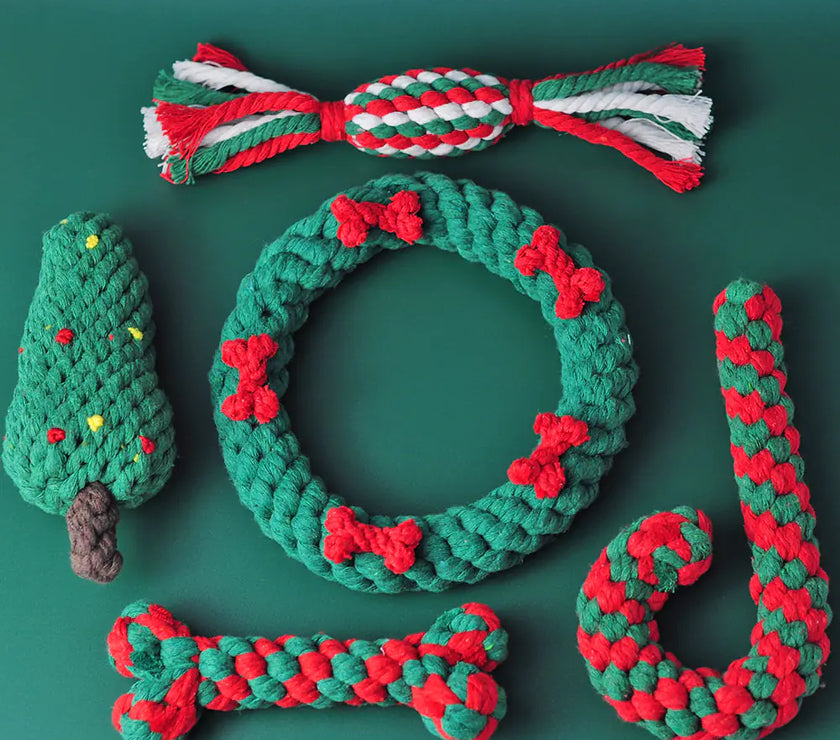 Set of Christmas-themed dog toys including a wreath, candy cane, and tree on a green background
